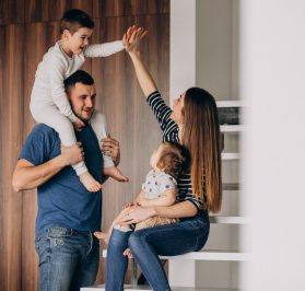 Young family with their little son at home having fun